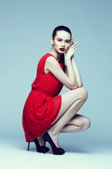 young elegant woman in red dress, fashion studio shot