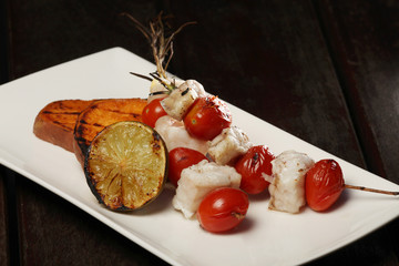 Gegrillte Fischspieße und Kirschtomaten  mit Scheiben von der Süßkartoffel