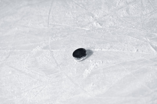 Hockey puck on the surface of ice rink