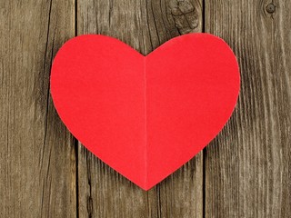 Red paper Valentines Day heart on vintage wood background