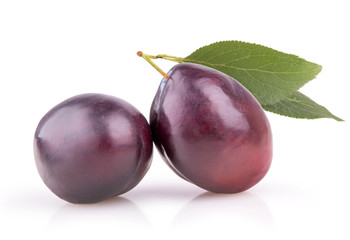 two ripe plums with leaves