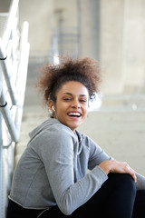 Smiling young woman listening to music with earphones