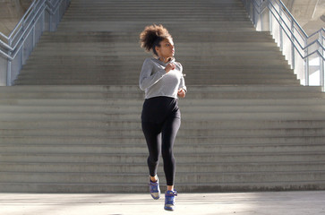Full length portrait of an attractive young black woman jogging