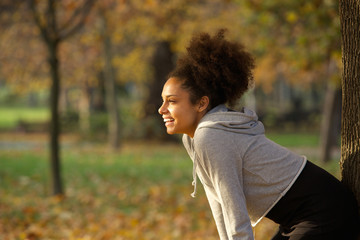 Young woman smiling and resting after workout in the park