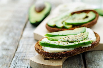 sandwich of rye bread with avocado and goat cheese