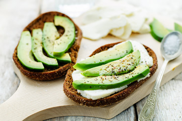 sandwich of rye bread with avocado and goat cheese