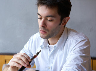 Young man smoking electric cigarette