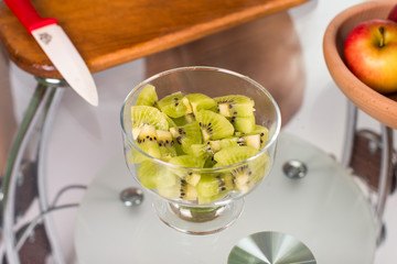 Portrait of pregnant mother cuts kiwi fruit