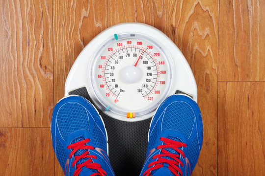 A Pair Of Man's Feet Standing On A Scale