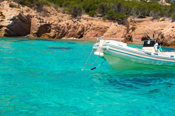 Fototapeta na wymiar Small boat in turquoise clear sea