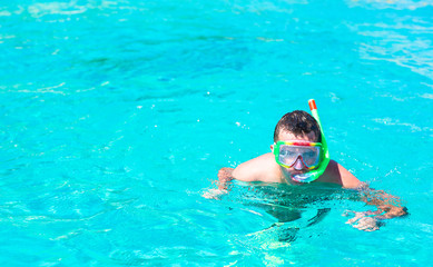Naklejka premium Young man snorkeling in clear tropical turquoise waters