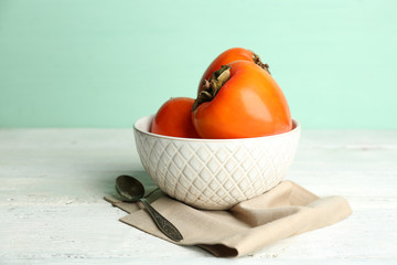 Ripe sweet persimmons, on wooden table