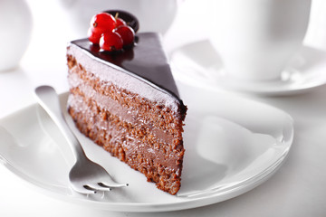 Delicious chocolate cake on plate on table on light background