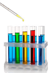 Pipette with drop of color liquid over container tubes isolated