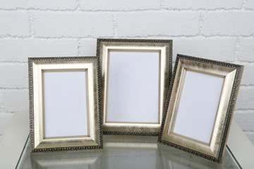 Photo frames on coffee table on brick wall background