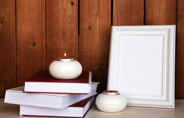 Photo frames with candles and books