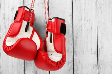 Pair of boxing gloves on color wooden background