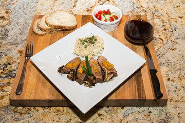 An exquisite display of beef with mashed potatoes, salad, bread and red wine.