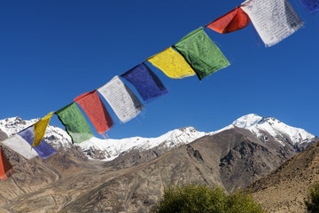 snow mountain range and tibetan prayer flags in the village - 75914275