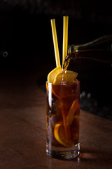 Barman prepares Cuba libre cocktail in a tall glass
