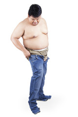 Man with fat body try to wear his old jeans