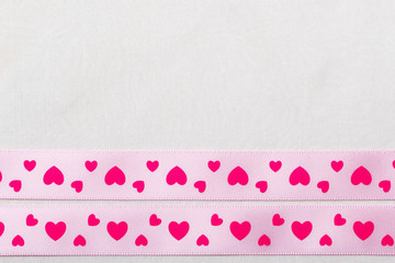 Pink heart ribbon on cloth background