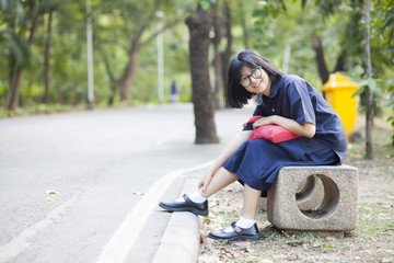 Fototapeta na wymiar Girl wearing glasses sitting on a bench along the corridor.