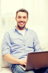 smiling man working with laptop at home