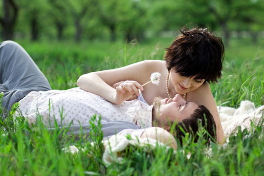 Young tenderness couple relax in blossoming garden