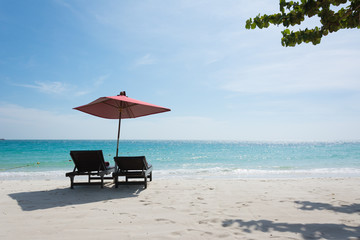 Two Beach chairs with umbrella and beautiful sand beach