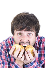 Young man eating biscuits greedily.