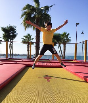 Bambino che gioca e salta su tappeto elastico