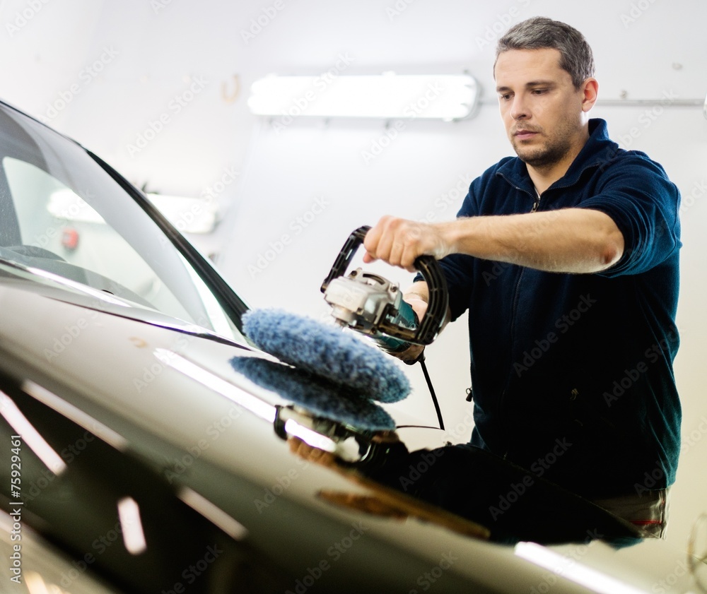 Poster Man on a car wash polishing car with a polish machine