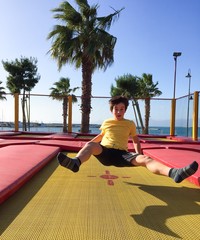 Bambino che gioca e salta su tappeto elastico © Uncleraf