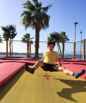 Bambino che gioca e salta su tappeto elastico
