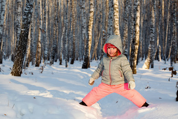 A little girl playing in a birch grove