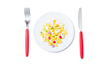 Bunch of colored pills on a white plate