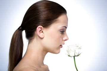 Naklejka premium Side view portrait of attractive young woman with flower