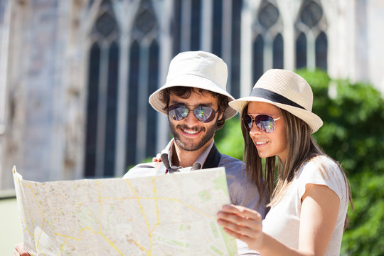 Happy tourists couple holding a map