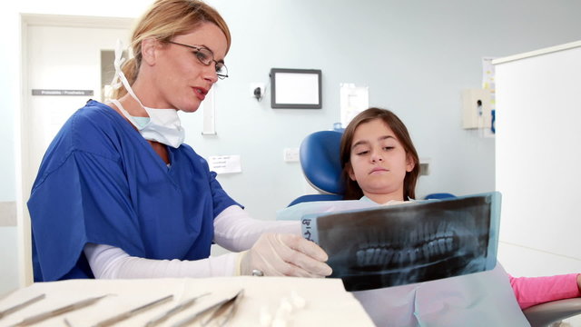 Dentist showing x-ray to little girl
