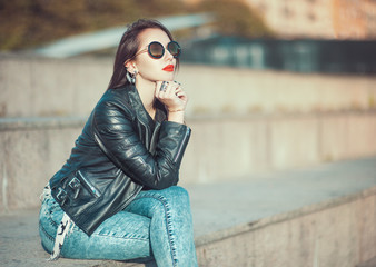 Young fashion beautiful girl in leather jacket and sunglasses