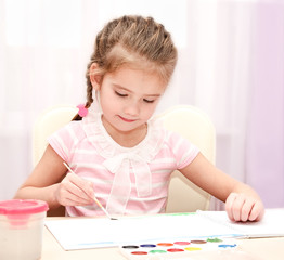 Cute little girl drawing with paint and paintbrush
