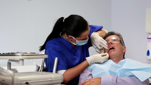 Dentist comparing shades of white to patients teeth