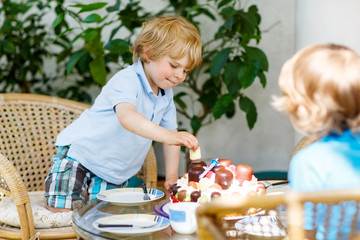 Little boy celebrating his birthday in home's garden with big ca