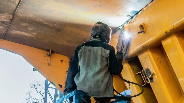 time lapse of welder reparing bucket of big yellow dumper