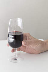 Old woman hand holding a glass of wine