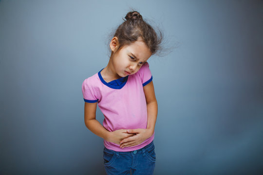 Teen girl child abdominal pain on gray background