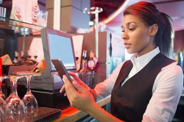 Pretty barmaid using touchscreen till