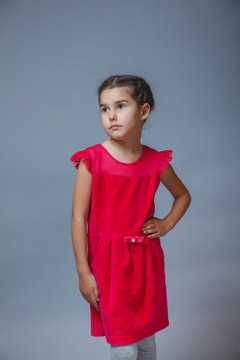 Teen girl in red dress looking thoughtfully into the distance