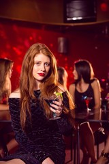 Obraz na płótnie Canvas Pretty redhead drinking a cocktail